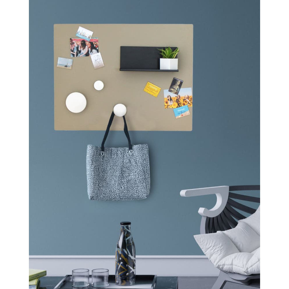 Die Tafel hält Postkarten, Taschen und Deko-Magnete – Beige trifft auf dunkles Blau und schafft einen stilvollen, urbanen Look im Flur oder