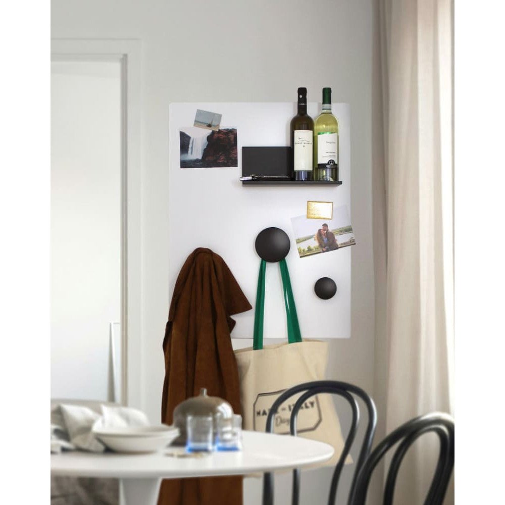 In einem hellen Eingangsbereich bietet die weiße Kreidetafel vielseitige Nutzung Weinflaschen, Fotos und Taschen werden magnetisch befestigt