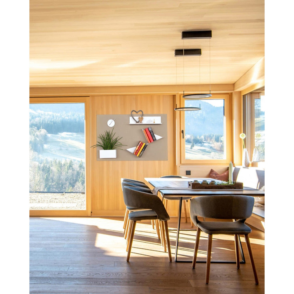 In einer hellen Holzstube montiert, passt sich die beigefarbene Tafel harmonisch ins Interieur ein. Bücher, Pflanze und Dekoobjekte zeigen,