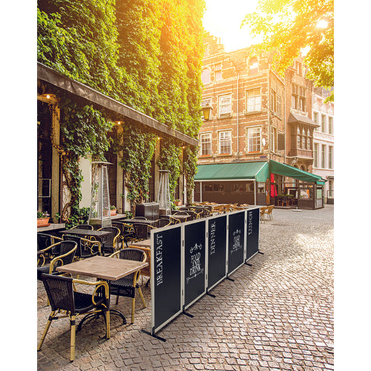 Kreidetafel mit Holzrahmen in weiss, aufgestellt vor einem Restaurant als Werbung und Sichtschutz