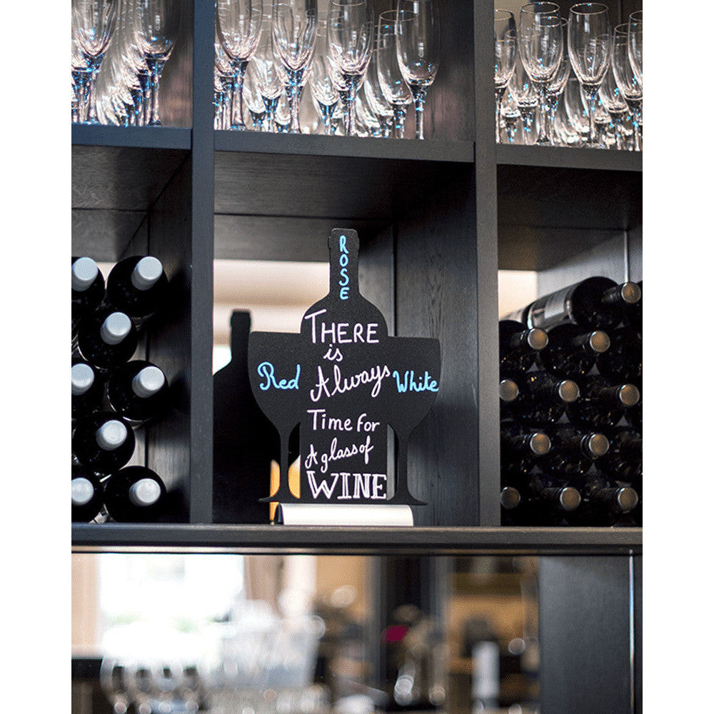Tischkreidetafel in Weinflaschen Form Silhouette beschriftet mit einem Weinspruch und aufgestellt in einer Vinothek im Weinregal