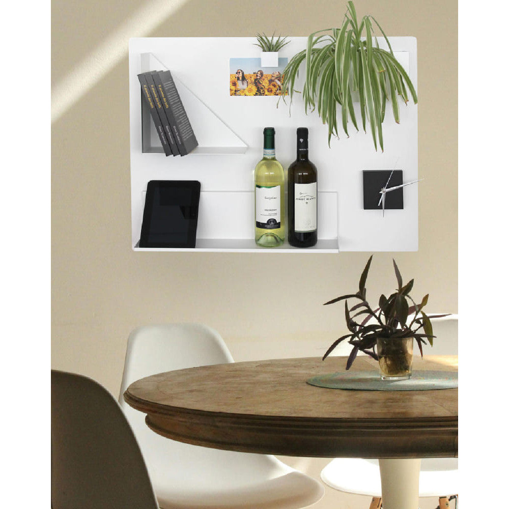 Über dem Esstisch setzt die weiße Tafel einen eleganten Akzent. Magnetisch befestigte Weinflaschen, Bücher und Pflanzen schaffen ein moderne