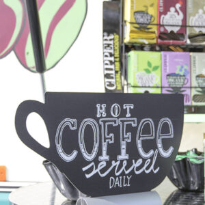 beschriftete Tischtafel Silhouette Kaffeetasse mit Alufuss und aufgestellt in einer Bar mit einem Kaffeespruch beschriftet